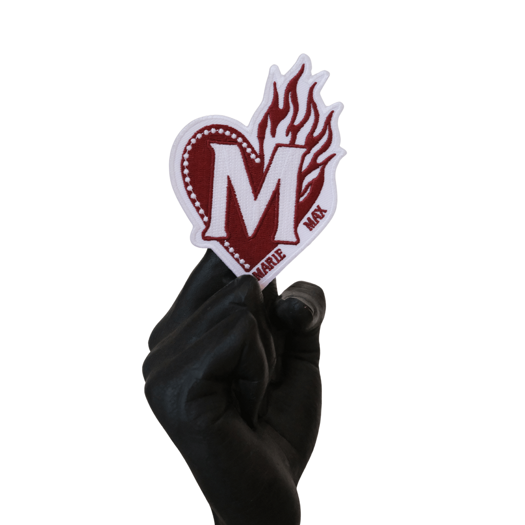 Patch écusson thermocollant représentant le logo Marie Max posé sur une main